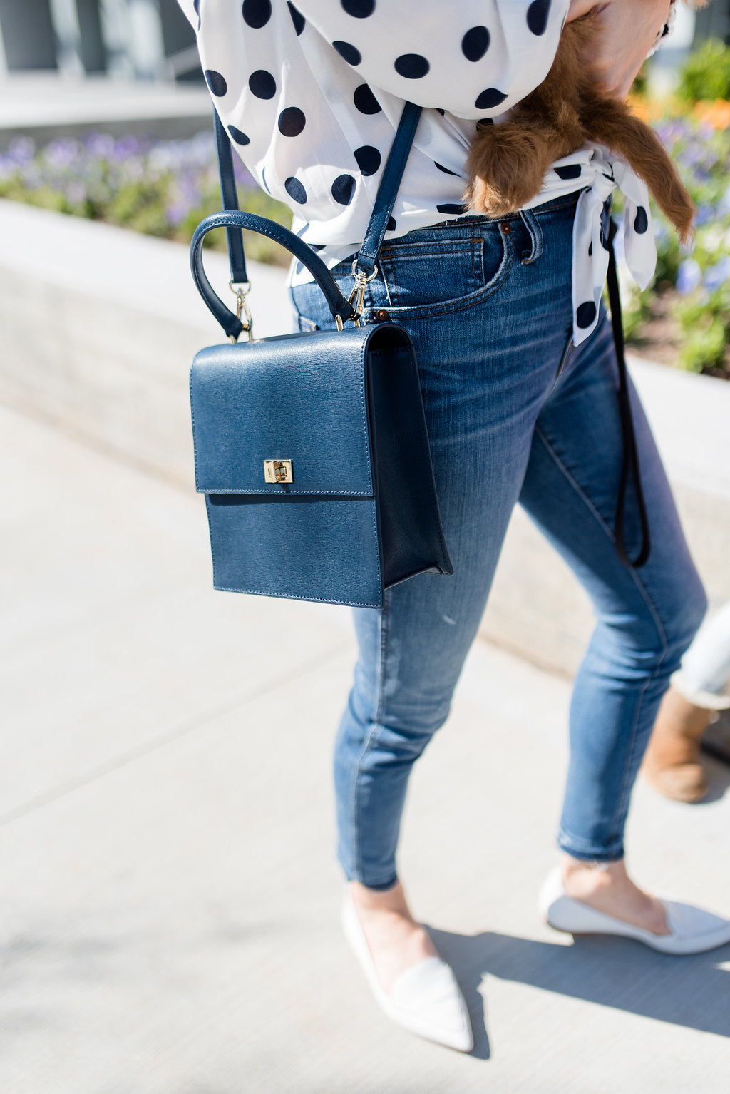 navy cross body bag with jeans and polka dot top